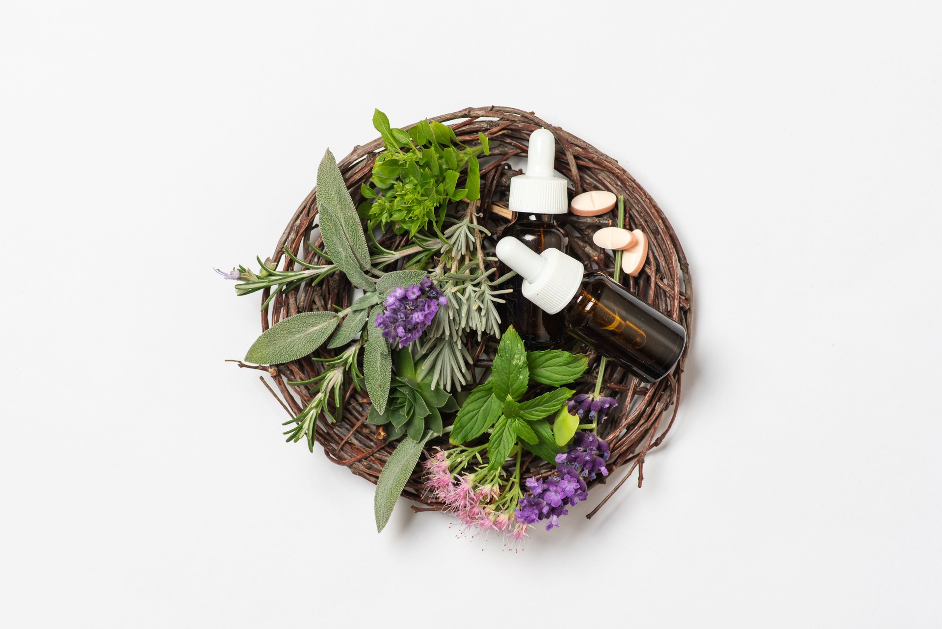 Herbal assortment with essential oils on a rustic woven plate