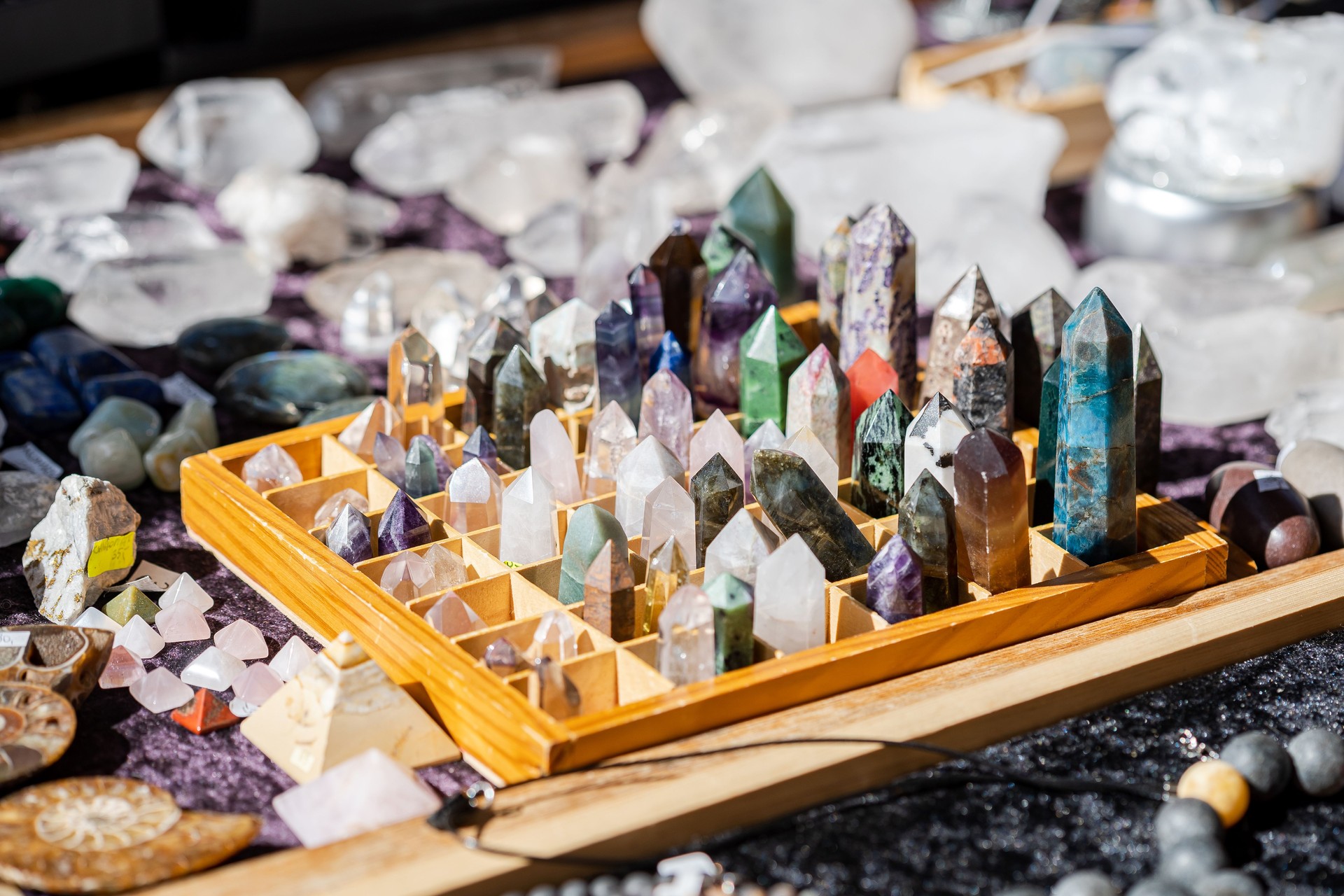 Lots of simple small multi colored decorative crystals on sale, group of objects detail closeup, shallow dof Large set of many natural colorful decoration crystals in store up close, nobody, no people